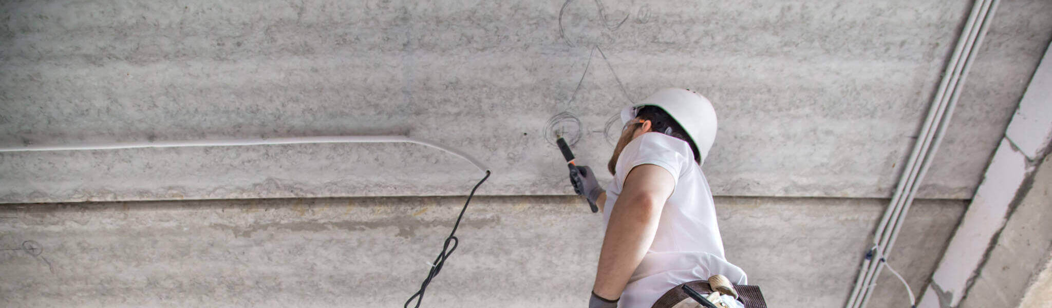 Electrician Installer With A Tool In His Hands, Working With Cable On The Construction Site.